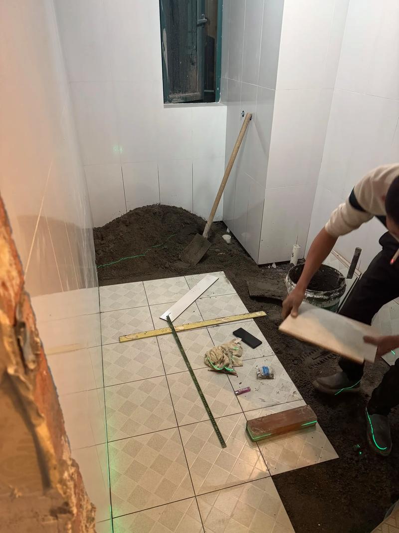 装修工人正在用水泥砂浆铺贴卫生间地砖