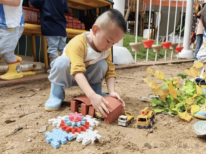 幼儿蹲在小区沙池角落看其他小朋友玩