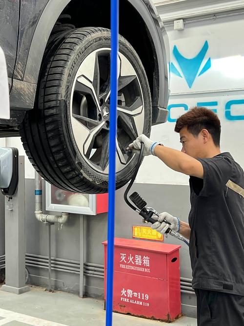 维修技师晃动汽车轮胎检查轮毂轴承旷量