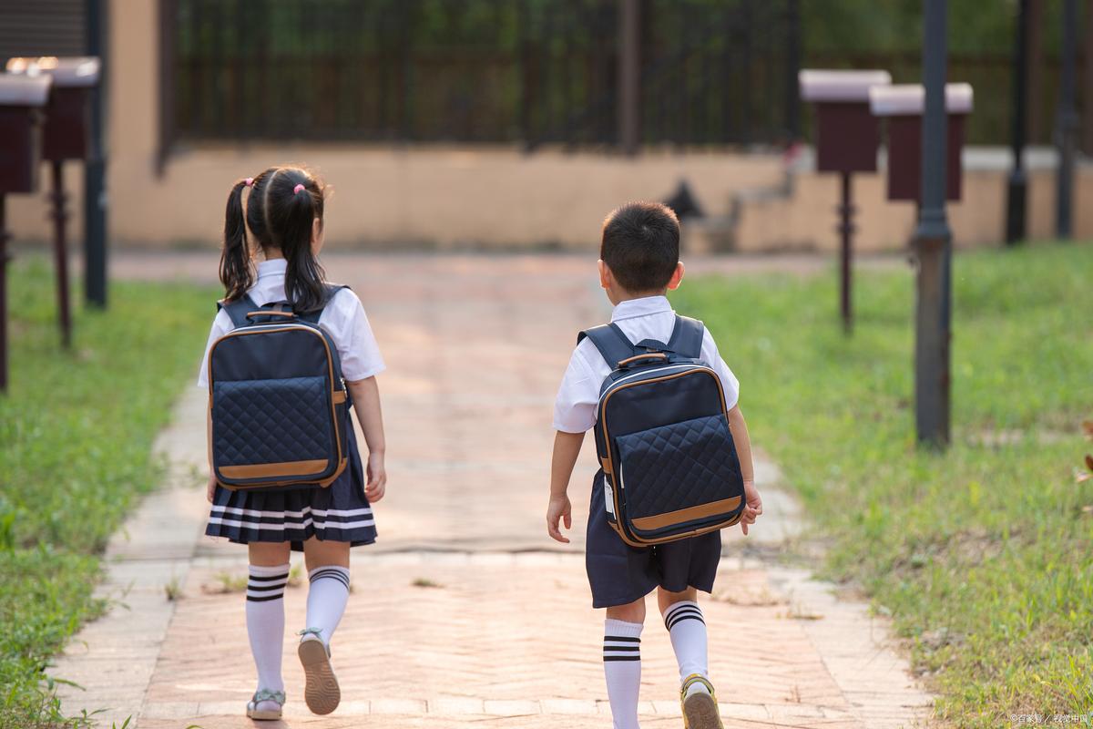 六岁孩子背书包上小学背影
