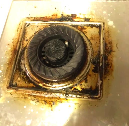 燃气灶火盖火孔被油垢面渣堵塞特写
