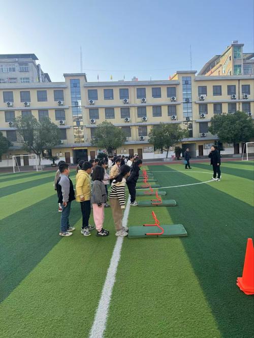 小学课间体育老师带学生针对性练习立定跳远现场