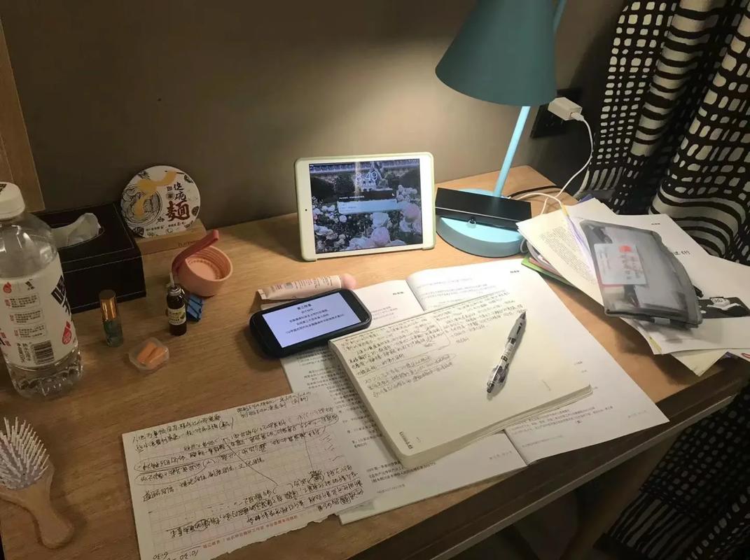 高中生深夜台灯下学习桌面堆满书本草稿