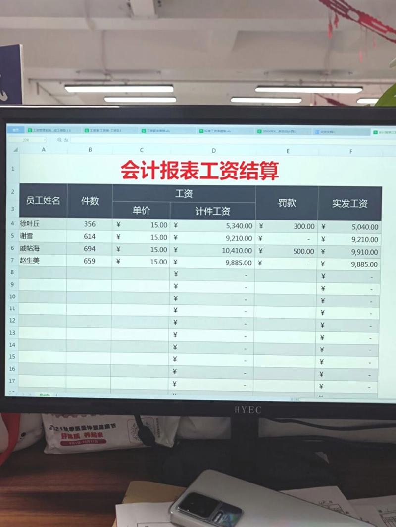 员工在办公电脑前核对工资条明细场景