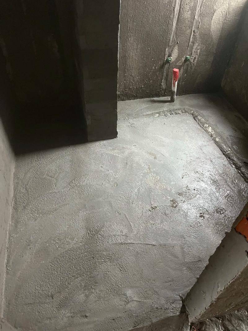 工人正在卫生间地面泼水测试排水坡度