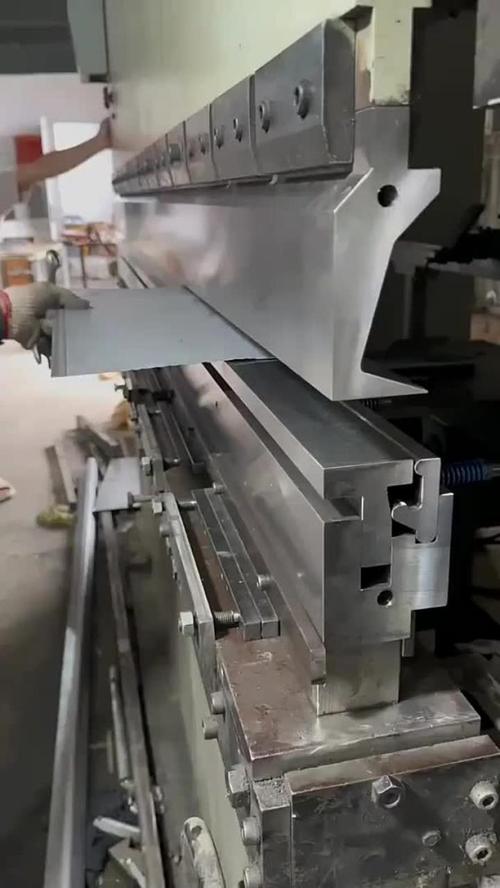 折弯机操作工正在更换模具并调整刀架