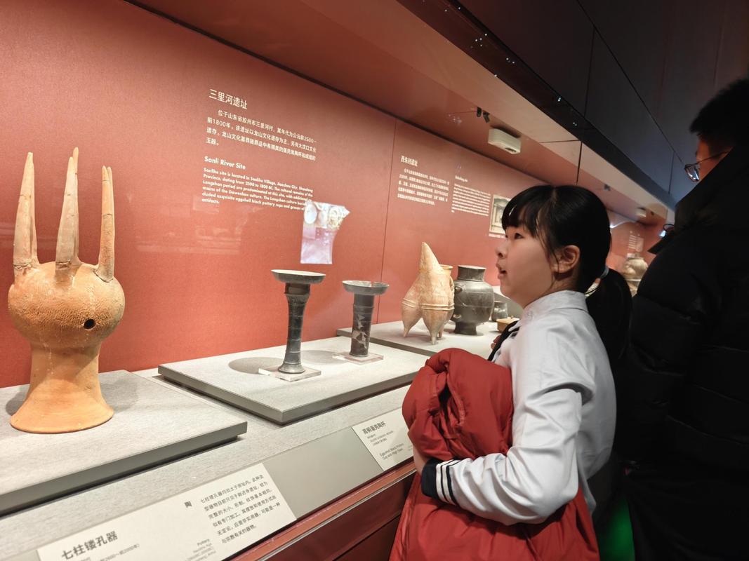博物馆里孩子趴在展柜前观看青铜器