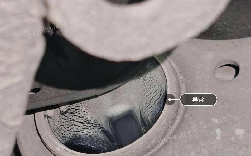 汽修师傅蹲在车轮旁检查下摆臂胶套开裂情况