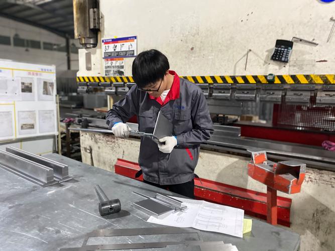 车间凌晨折弯机旁质检员挑不合格折弯件现场