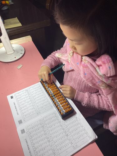 妈妈陪孩子在小区石桌做口算题场景