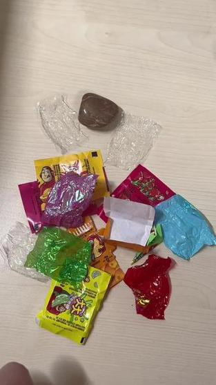 孩子细心整理自己收藏的糖纸和石头