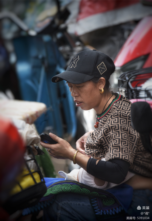 街头糖炒栗子摊子旁拿着手机打电话的路人