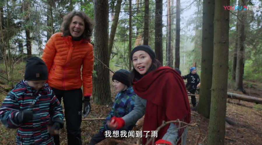 周轶君在芬兰森林里和孩子们一起采蘑菇的画面