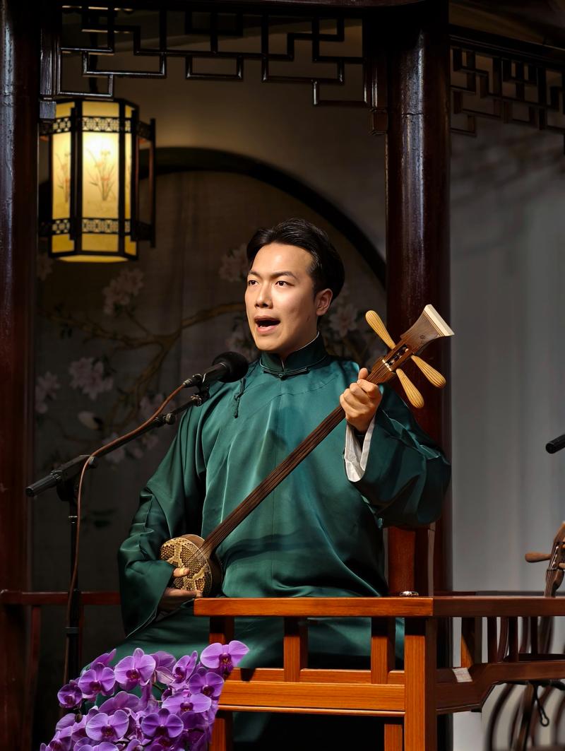 评弹艺人在茶馆台上弹三弦演出
