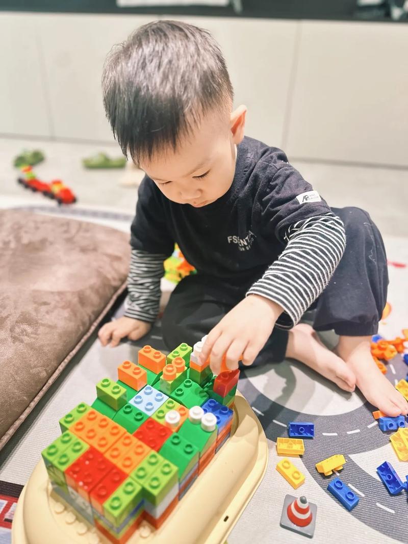 一个孩子正在拼乐高积木，表情沮丧但专注