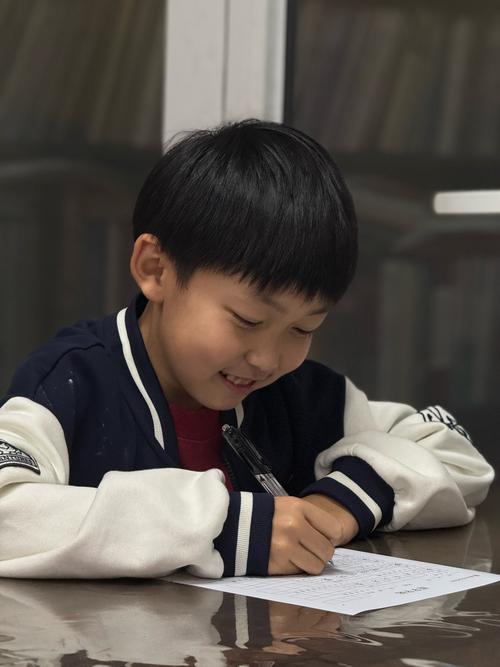 小学课堂上攥着铅笔低头的小男孩侧脸