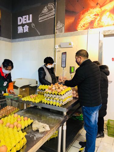 社区水果店老板蹲店门口吃盒饭的实拍