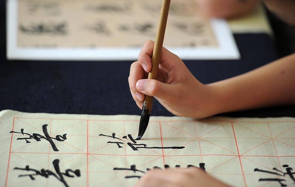 初学者练习书法使用毛边纸和兼毫毛笔的场景