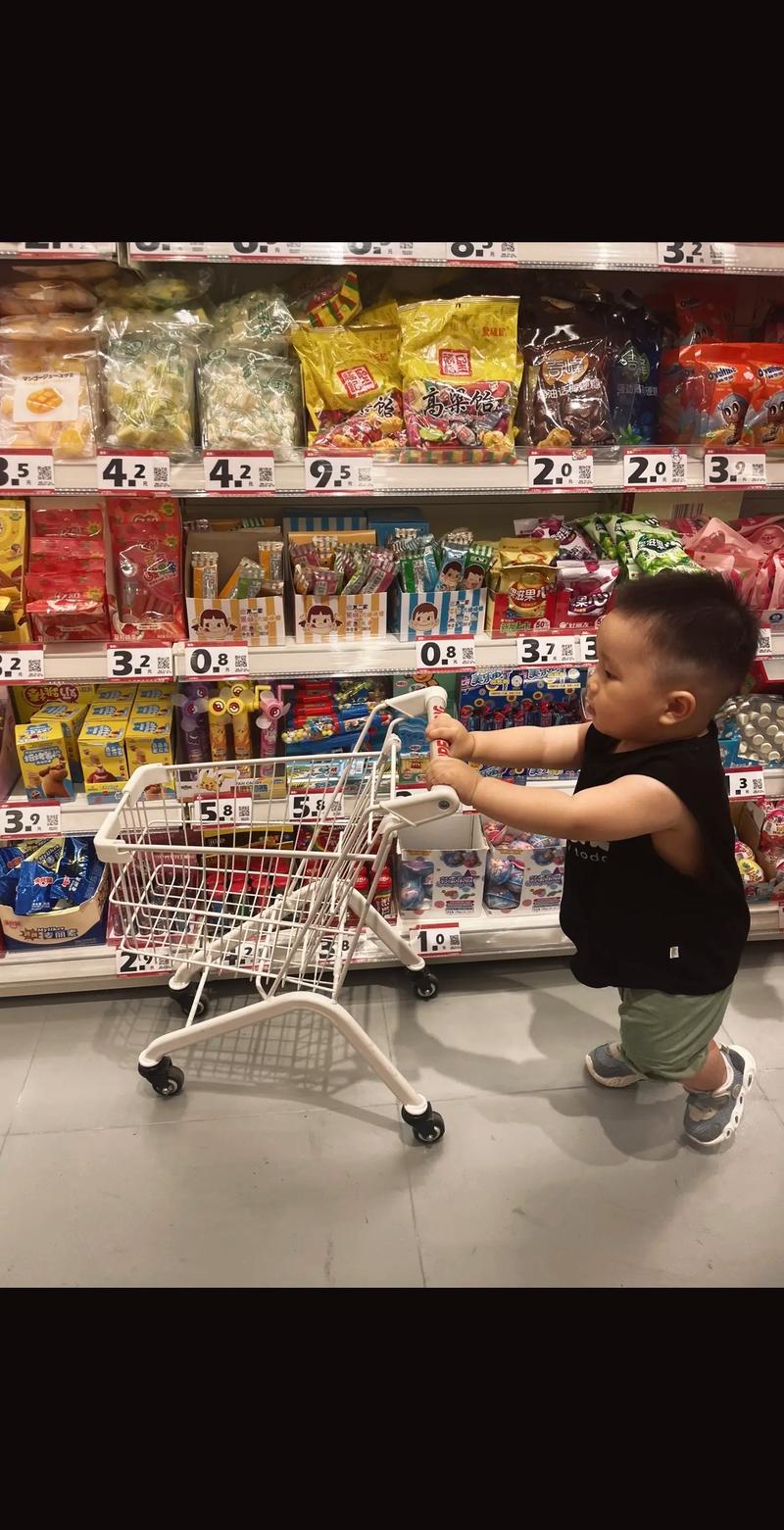 小朋友好奇地盯着光头叔叔的头顶在超市里