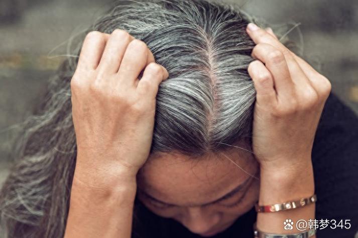 窗边阳光下女生对着镜子拔白头发场景