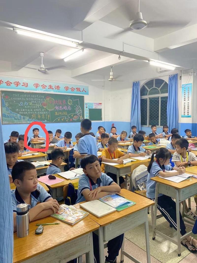 城郊民办小学教室后排独自坐的小学生