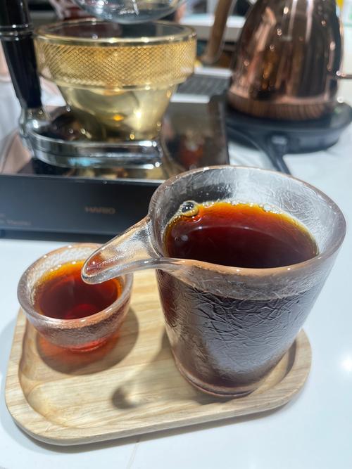 一杯手冲耶加雪菲咖啡特写,旁边散落着咖啡豆