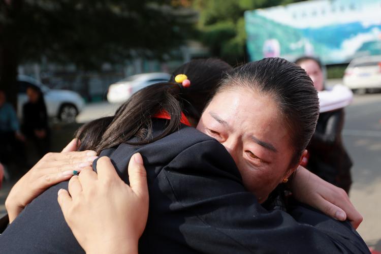 家长蹲下来拥抱比赛落选哭泣孩子的场景