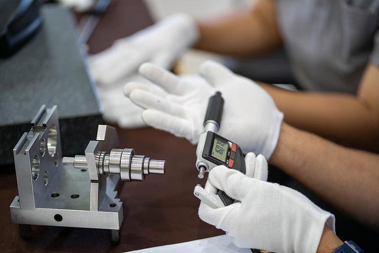 工厂车间操作人员使用千分尺手动测量零件尺寸细节图