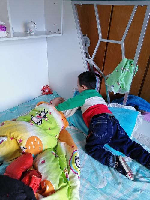 凌晨早醒后坐床玩耍的婴幼儿实拍