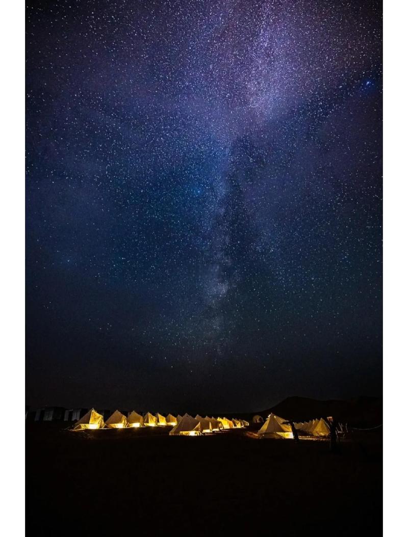 荒漠夜空银河拱桥与帐篷微光