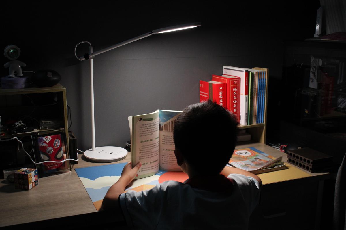 学生深夜台灯下写作业迷茫表情