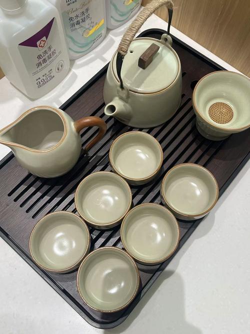 厨房台面上放着带使用痕迹的陶瓷马克杯和旧鸣笛烧水壶
