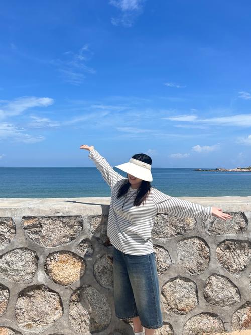穿戴完整防晒装备在海岛沙滩准备下水的游客全身照
