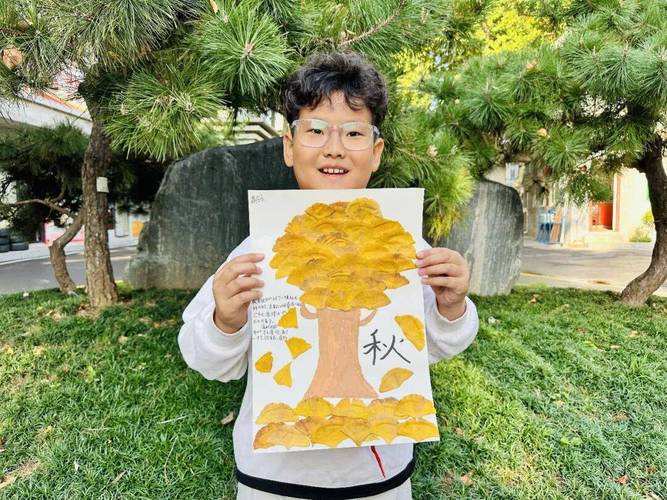 小学三年级学生把压好的梧桐叶贴在语文作业上