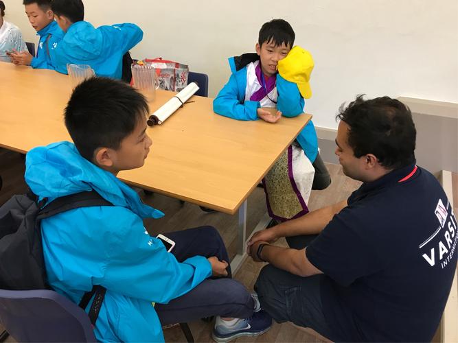 教师蹲下与小学生平视交流