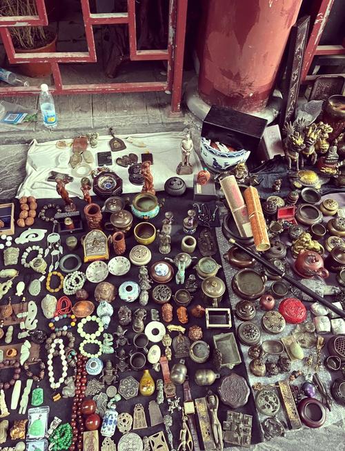 跳蚤市场上各种古董小物和手工艺品摊位前人们正在挑选