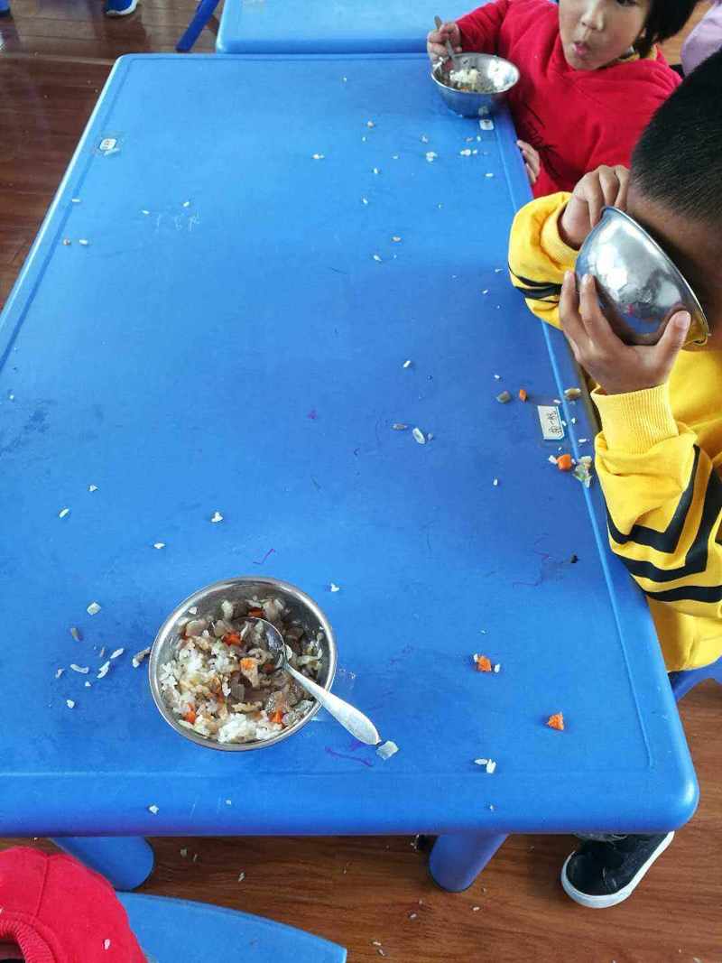 幼儿自己进食弄满桌面饭粒场景图