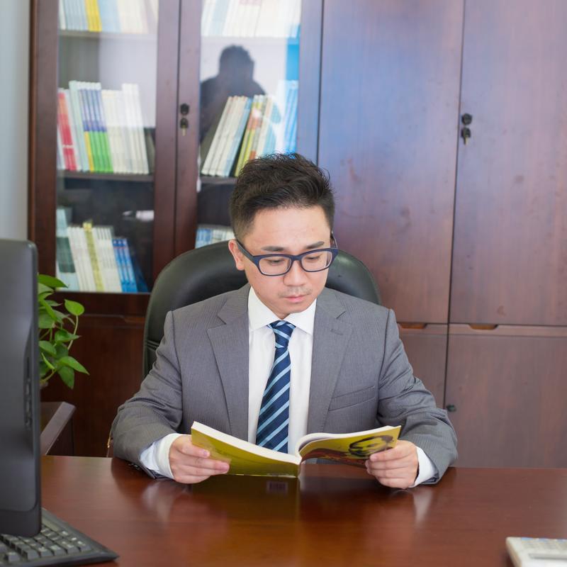 西装革履的人坐在办公桌前发呆