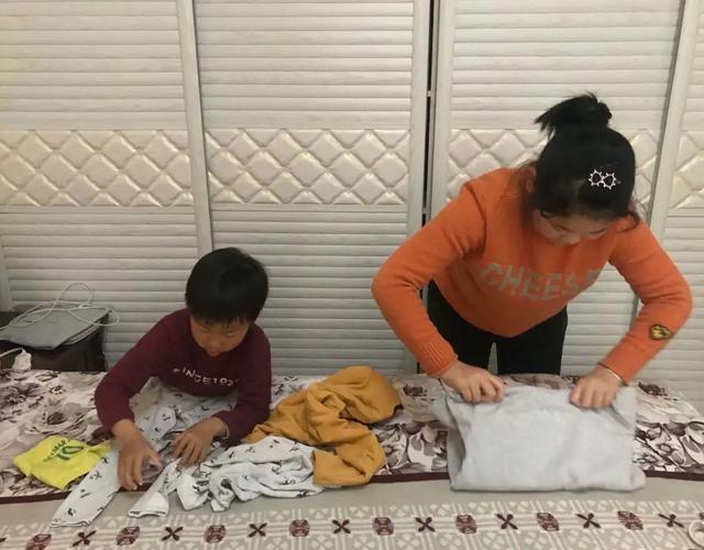 孩子和妈妈一起叠家里的换季衣服