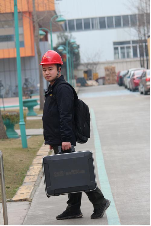 工业园区下班工人拎着工具包站在自家玄关