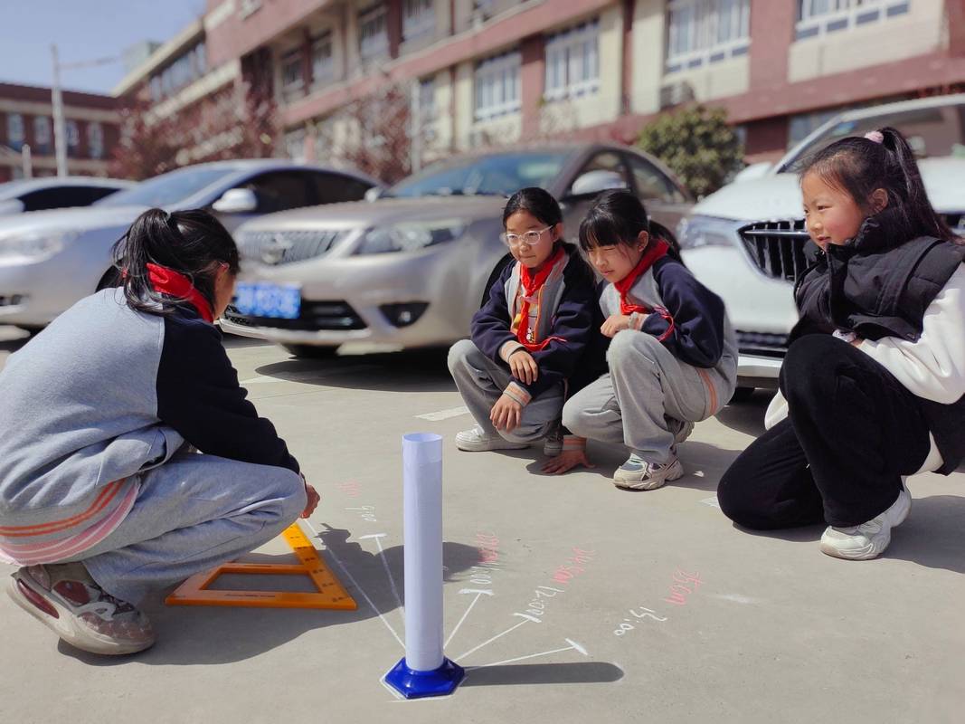 小学生举三角板在路灯下观察影子大小变化
