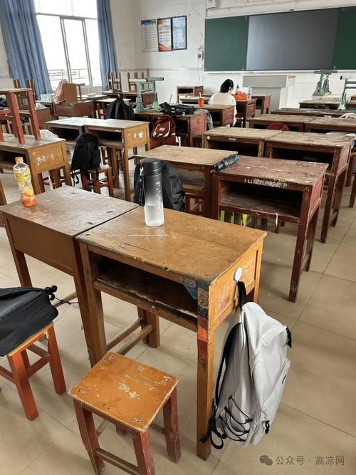小学教室后排挤着拼的旧课桌椅