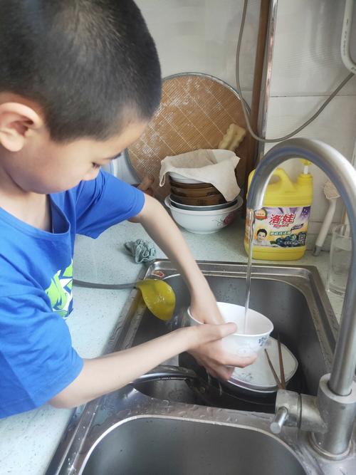 儿童在厨房自己倒水练习独立生活能力