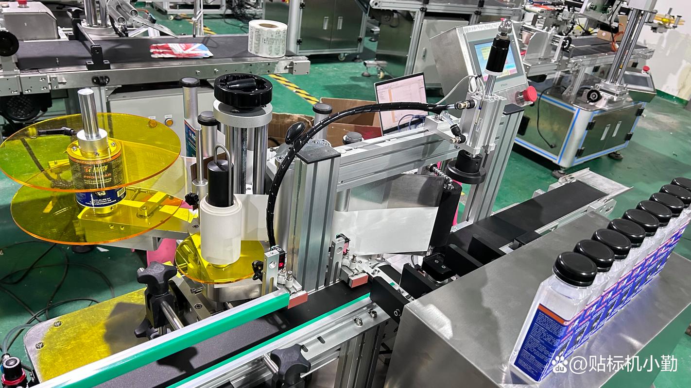 日化车间贴标机对准透明塑料瓶的工作特写