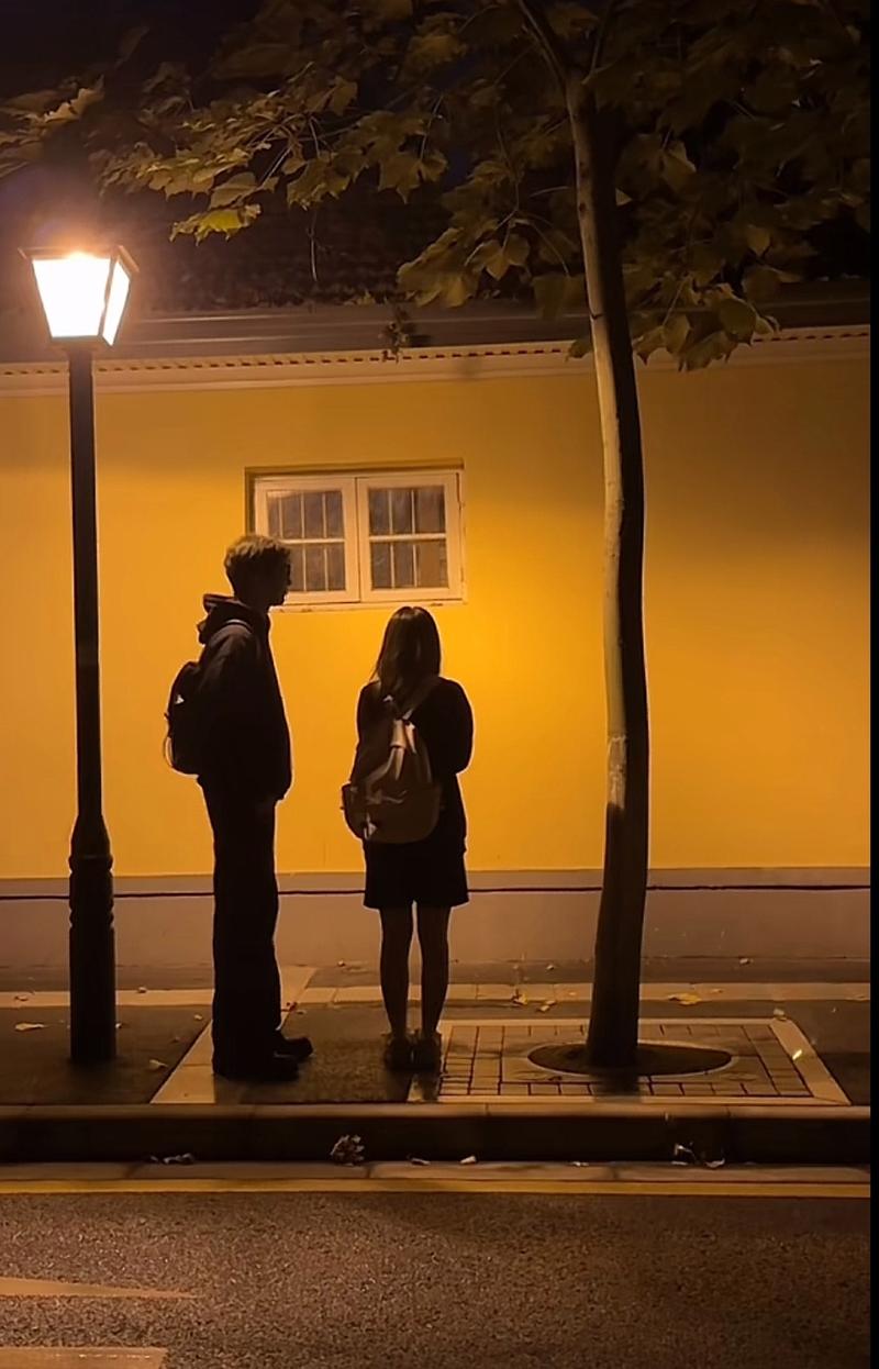 情侣一人追一人走在夜晚路灯下气氛拉扯