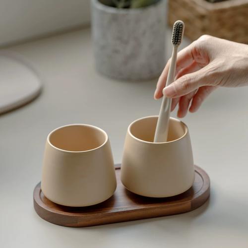 对齐厨房砖缝摆放的米白色陶瓷漱口杯
