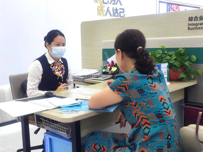 保险理赔窗口工作人员接待咨询用户的实拍图
