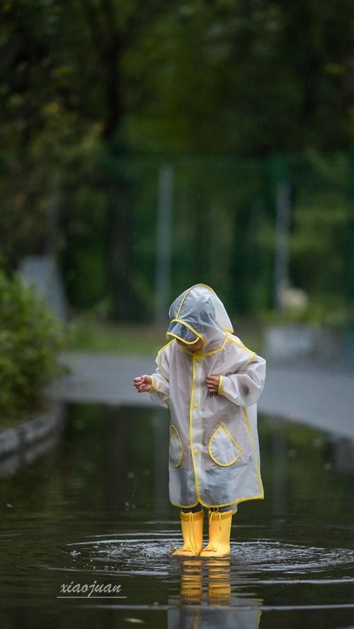 孩子仰头看雨滴下落观察自然现象图片