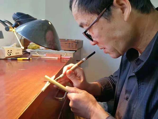 匠人对着自然光检查湖笔锋颖透亮度特写
