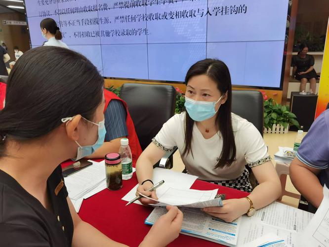 家长在教育局窗口咨询集体户划片入学统筹规则的实拍场景